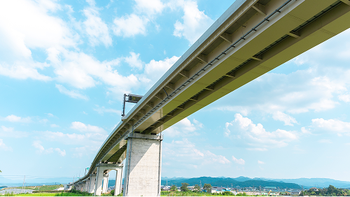 青空の下に架かる大きなコンクリート製の高架橋・インフラ設備